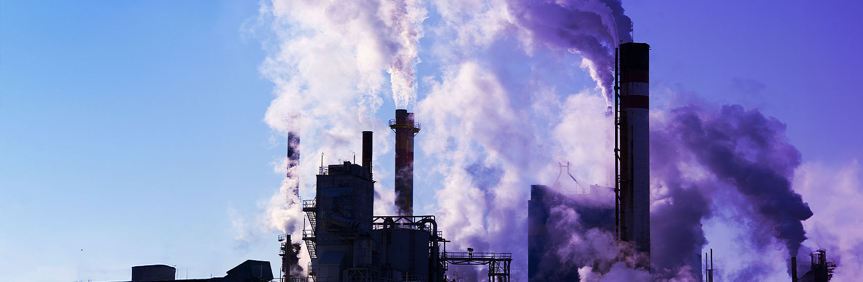 Symbolbild zum Umweltstrafrecht: Rauchende Schornsteine einer Fabrik