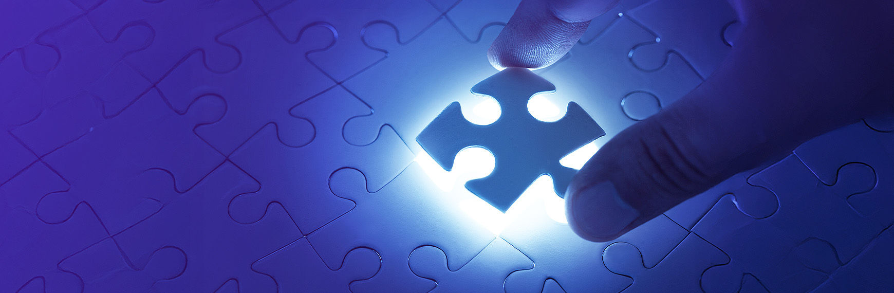 Symbolbild zu Carve-out:  zwei Finger lösen ein Teil aus Puzzle