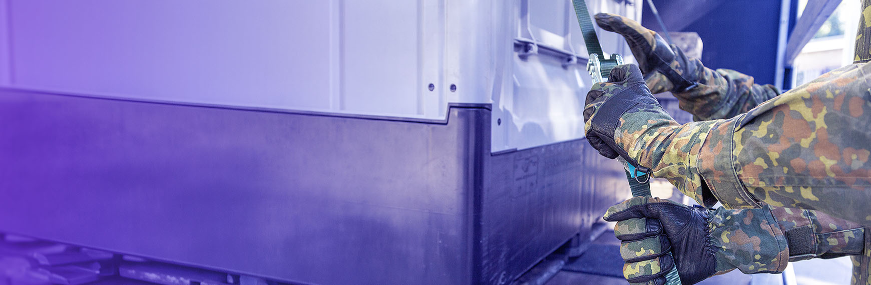 Symbolbild zum Beschaffungsbeschleunigungsgesetz: Arme von Bundeswehrsoldat schnüren Ladung